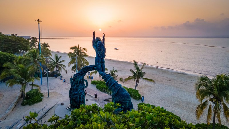El Portal Maya del Parque Los Fundadores al amanecer, con la playa y el Caribe detrás.